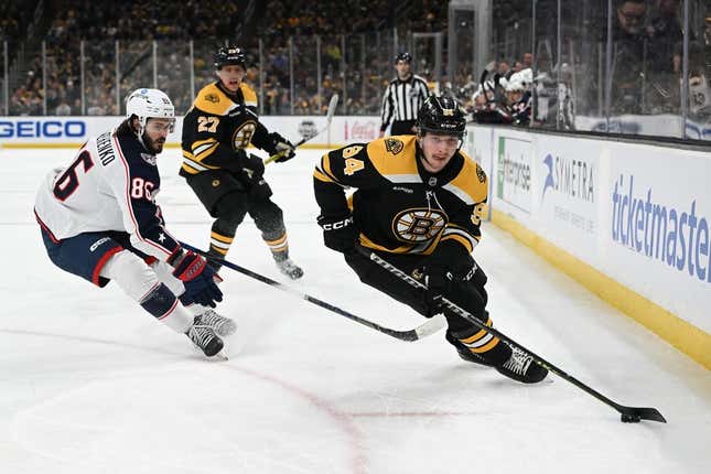 Mar 30, 2023; Boston, Massachusetts, USA; Boston Bruins center Jakub Lauko (94) controls the puck against Columbus Blue Jackets right wing Kirill Marchenko (86)  during the first period at the TD Garden.