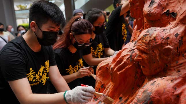 University students clean the "Pillar of Shame" statue at the University of Hong Kong on the 32nd anniversary of the crackdown on pro-democracy demonstrators at Beijing's Tiananmen Square in 1989, in Hong Kong, China June 4, 2021.