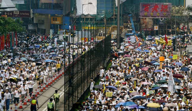 Protesters crowd a street at Hong Kong's Causeway Bay shopping district during a march July 1, 2004 on the seventh anniversary of the the handover of Hong Kong to China. Tens of thousands of Hong Kong people dressed in white poured onto the streets on Thursday to vent their frustration at Chinese rule and challenge Beijing's refusal to allow them to elect their own leaders