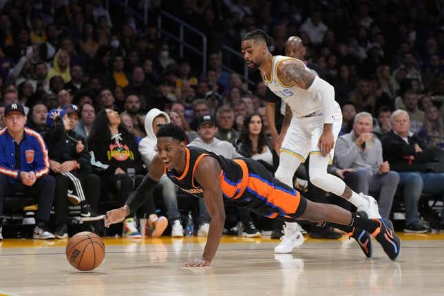 Mar 12, 2023; Los Angeles, California, USA; New York Knicks guard RJ Barrett (9) and Los Angeles Lakers guard D&#39;Angelo Russell (1) reach for the ball in the second half at Crypto.com Arena.