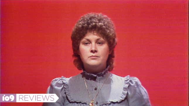 A woman with curly hair in front of a red background.