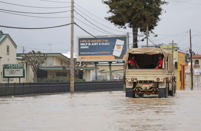 Photo of military vehicle driving in flood waters