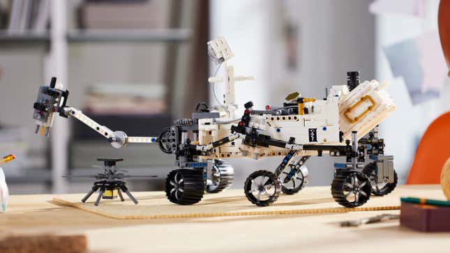 A side-shot of the Lego Mars Rover Perseverance model, with the Ingenuity helicopter landed right next to it.