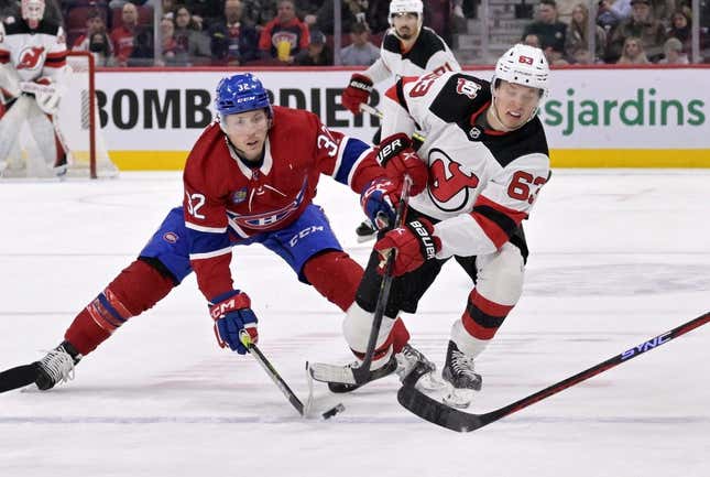 Mar 11, 2023; Montreal, Quebec, CAN; Montreal Canadiens forward Rem Pitlick (32) and New Jersey Devils forward Jesper Bratt (63) battle for the puck during the first period at the Bell Centre.