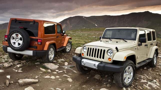 A photo of two Jeep Wrangler SUVs on top of a hill. 