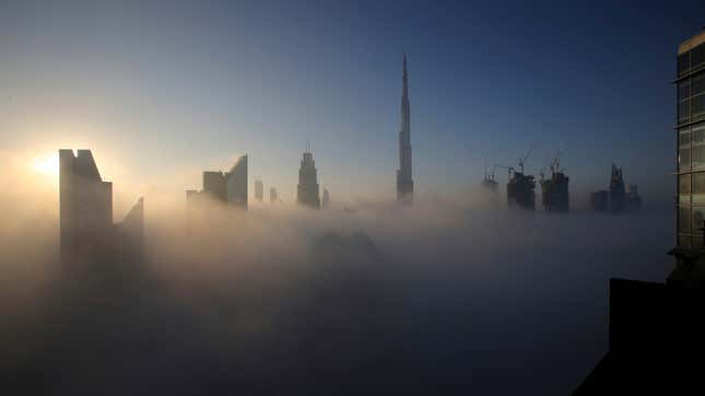 The sun rises over the city skyline with the Burj Khalifa, the world’s tallest building at the backdrop, seen from a balcony on the 42nd floor of a hotel on a foggy day in Dubai, United Arab Emirates.