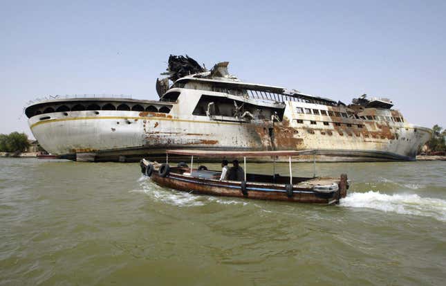 Image for article titled Saddam Hussein's Overturned Yacht is a curious attraction for Iraqi sightseers and locals