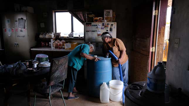 Nancy Bitsue, an elderly member of the Navajo Nation, receives her monthly water delivery in the town of Thoreau, New Mexico.