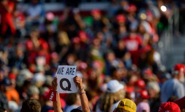 MOON TOWNSHIP, PA - SEPTEMBER 22: A woman holds up a QAnon sign to the media as attendees wait for President Donald Trump to speak at a campaign rally at Atlantic Aviation on September 22, 2020 in Moon Township, Pennsylvania. 
