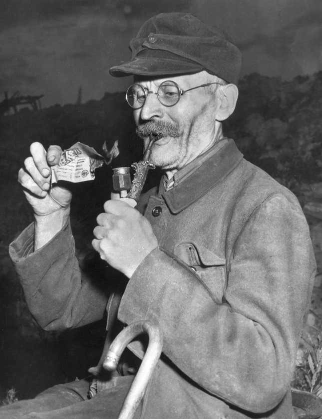 A man lights his pipe with a useless reichsmark, on June 20, 1948, the day the deutsche mark was introduced.