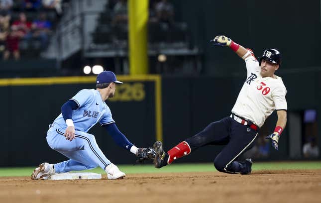 Texas Rangers' Nathaniel Lowe (30) is tagged out by Toronto Blue Jays  second baseman Cavan Biggio (8) during the 8th inning of a baseball game in  Arlington, Texas, Friday, June 16, 2023.