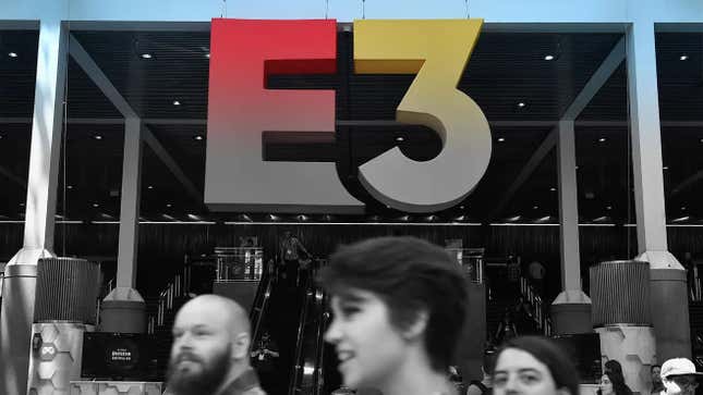 People walk in front of a E3 sign. 