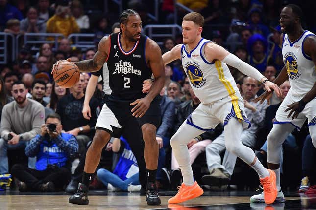 Mar 15, 2023; Los Angeles, California, USA; Los Angeles Clippers forward Kawhi Leonard (2) moves the ball against Golden State Warriors guard Donte DiVincenzo (0) during the first half at Crypto.com Arena.