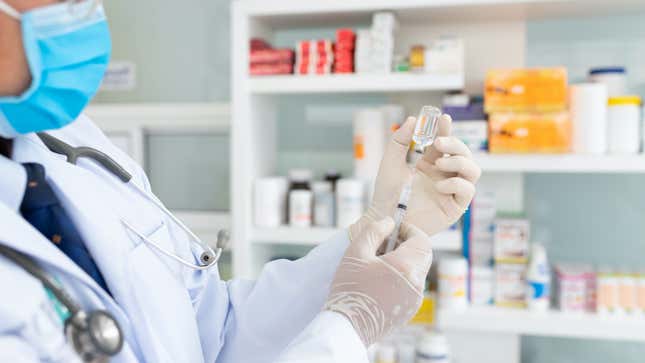 pharmacist draws a vaccine from a vial