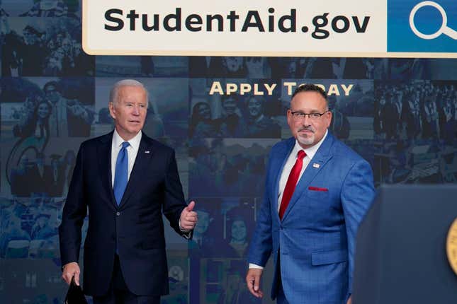 President Joe Biden answers questions with Education Secretary Miguel Cardona as they leave an event about the student debt relief portal beta test in the South Court Auditorium on the White House complex in Washington, Oct. 17, 2022.