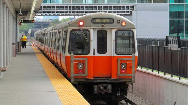 A photo of an Orange Line train pulling into a station in Boson. 