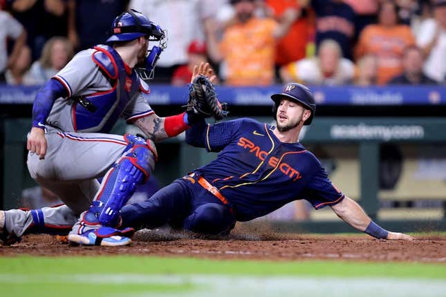 Jul 24, 2023; Houston, Texas, USA; Houston Astros right fielder Kyle Tucker (30) slides into home plate to score the game winning run while beating the tag of Texas Rangers catcher Jonah Heim (28) during the ninth inning at Minute Maid Park.