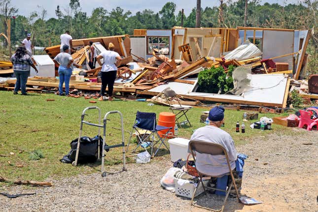 Elnora Ross sits outside her damaged home as friends and neighbors help salvage her belongings after a tornado struck off Country Road 16, on June 19, 2023 in Louin, Mississippi.