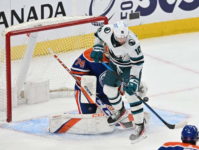 Apr 13, 2023; Edmonton, Alberta, CAN;   Edmonton Oilers goalie Stuart Skinner (74) battles for the puck with  San Jose Sharks left winger Evgeny Svechnikov (10) during the first period at Rogers Place.
