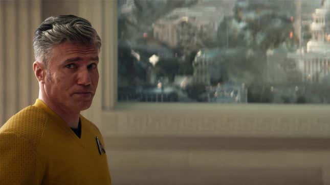 Captain Pike stands with a pleading face in front of a viewscreen depicting a destroyed U.S. Capitol during the events of Star Trek's World War III.