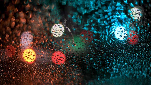 Car lights seen through a rainy window