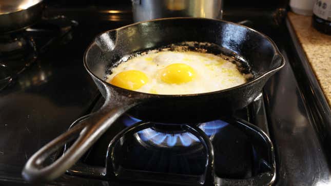 Stock photo of eggs cooking over gas stove