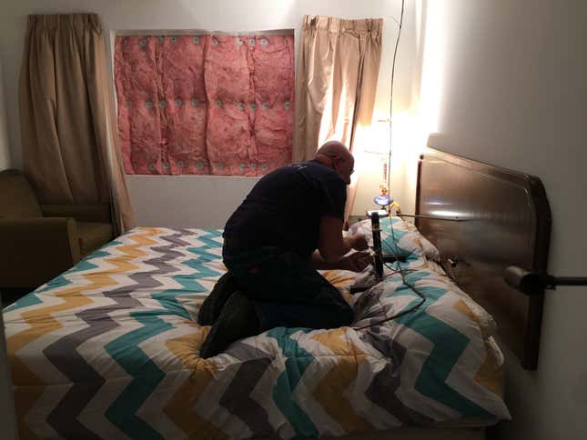 A UL worker installing sensors in a fake house they’re about to set on fire.