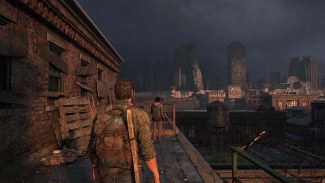 In an image from the game The Last of Us, Joel stands on a rooftop and in the distance, one skyscraper can be seen leaning against another.