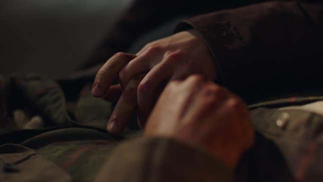 Ellie's fingers intertwine with Joel's in a shot from HBO's The Last of Us.