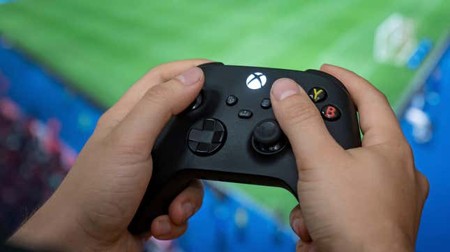 A man holds a controller of the Xbox Series X gaming console.