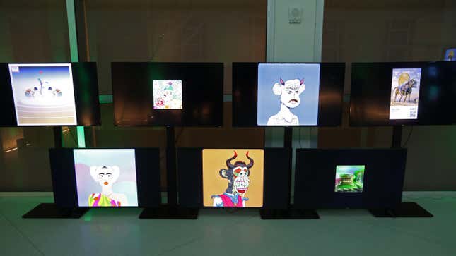 A wall of television screens displays several types of NFTs including bored apes.