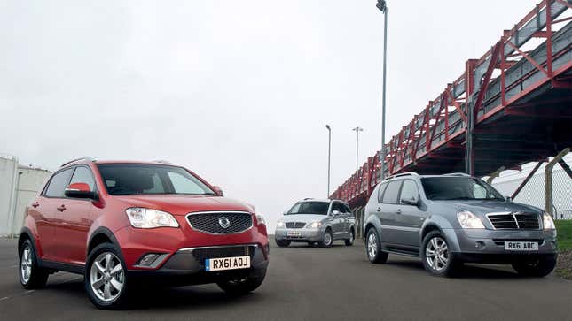 Three SsangYong cars parked by a bridge 
