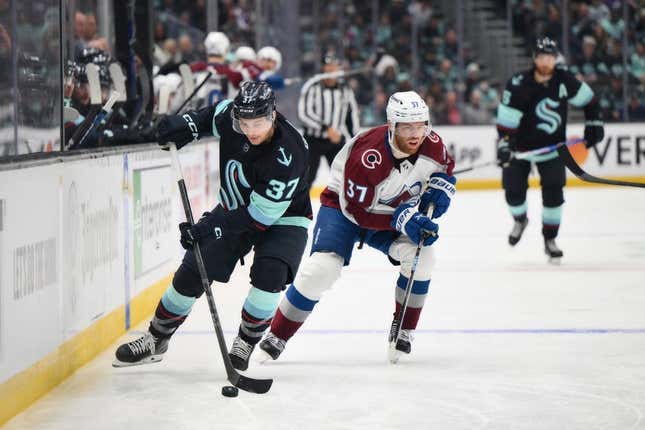 Apr 22, 2023; Seattle, Washington, USA; Seattle Kraken center Yanni Gourde (37) advances the puck while being chased by Colorado Avalanche left wing J.T. Compher (37) during the second period in game three of the first round of the 2023 Stanley Cup Playoffs at Climate Pledge Arena.