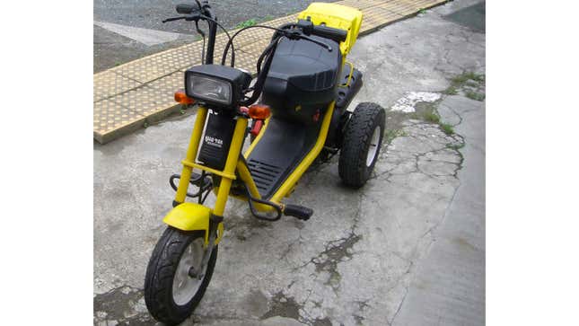 A photo of a yellow Honda Road Fox trike. 