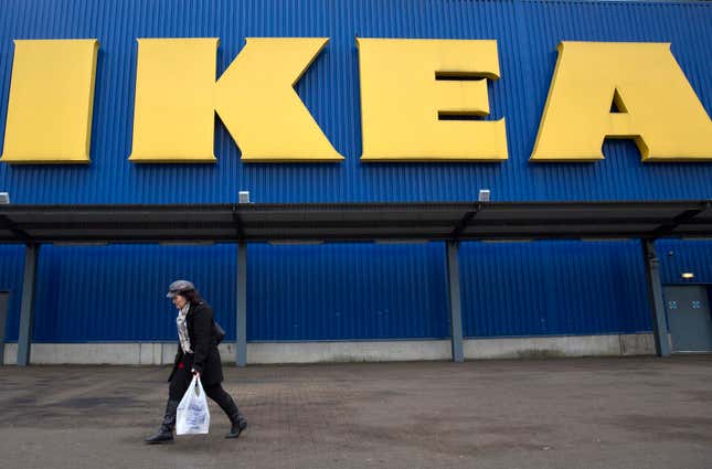 A shopper walks past an IKEA sign, UK. 