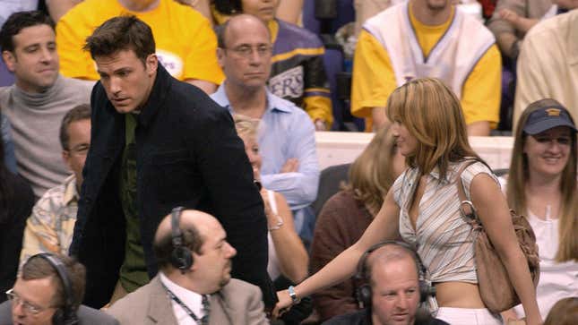 Ben Affleck holds Jennifer Lopez's hand as the two walk through the crowd of a Lakers game in 2003