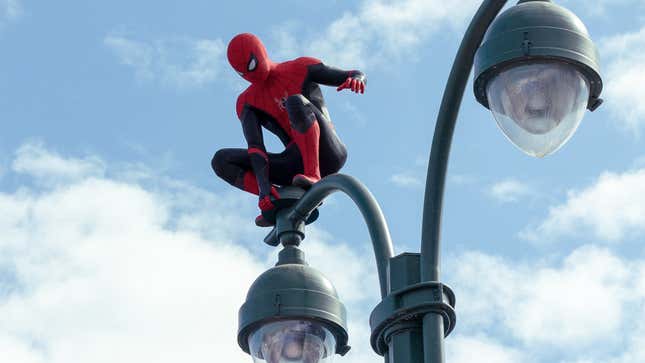 Peter Parker, in costume as Spider-Man, sits perched atop a New York City street lamp.
