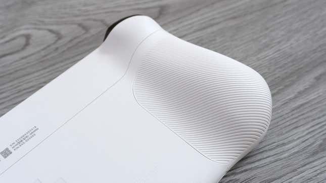A close-up of one of the textured grips on the back of the Logitech G Cloud against a gray wooden background.