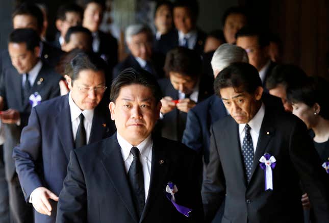 A group of lawmakers walk after offering prayers at the Yasukuni Shrine in Tokyo August 15, 2014, to mark the 69th anniversary of Japan's surrender in World War Two. Japanese Prime Minister Shinzo Abe on Friday sent a ritual offering to a Tokyo shrine to war dead but did not join cabinet ministers in a visit, seen as an effort to avoid further inflaming ties with China as he seeks a summit with Beijing. REUTERS/Yuya Shino