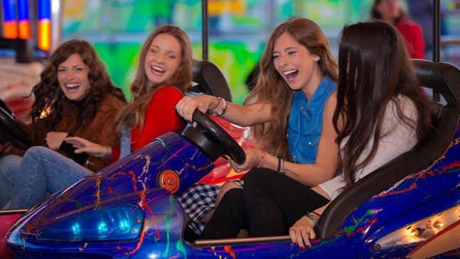 teenager riding bumper cars at amusement park