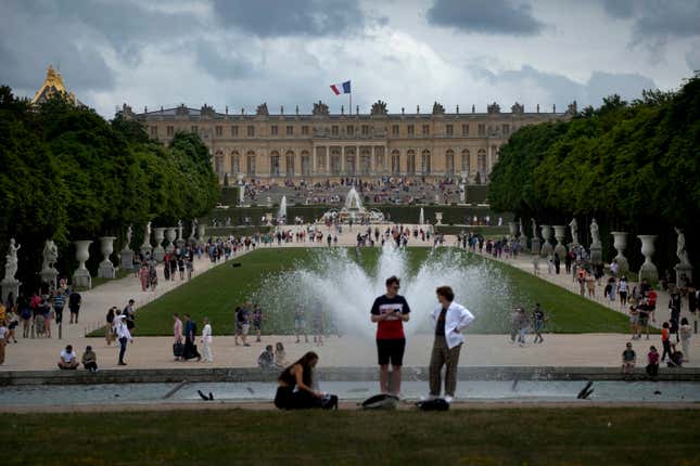 FILE - Visitors enjoy the Chateau de Versailles gardens, outside Paris, France, on July 15, 2023. France is rolling out the red carpet for King Charles III&#39;s state visit starting on Wednesday Sept. 20, 2023 at one of its most magnificent and emblematic monuments: the Palace of Versailles, which celebrates its 400th anniversary. (AP Photo/Christophe Ena, File)