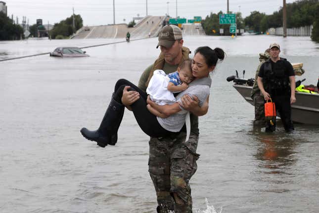 Houston Police SWAT officer Daryl Hudeck carries Catherine Pham and her 13-month-old son Aiden after rescuing them from their home surrounded by floodwaters from Tropical Storm Harvey on Aug. 27.