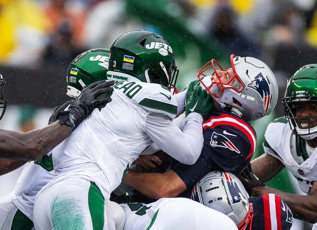 EAST RUTHERFORD, NEW JERSEY - SEPTEMBER 24:  Mac Jones #10 of the New England Patriots attempts a quarterback sneak in the second half as Jordan Whitehead #3 of the New York Jets makes the tackle  at MetLife Stadium on September 24, 2023 in East Rutherford, New Jersey.   (Photo by Al Bello/Getty Images)