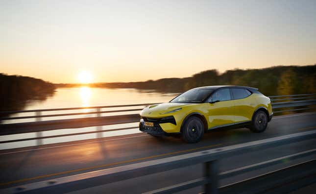 A yellow 2024 Lotus Eletre S SUV crosses a bridge at sunset