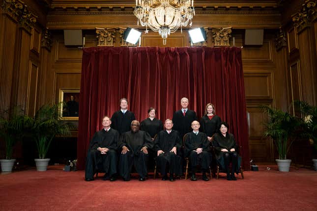 Members of the Supreme Court pose for a group photo at the Supreme Court in Washington.