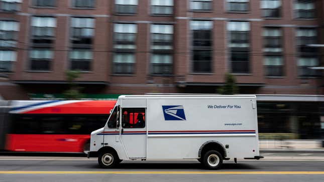 A US postal truck driving through traffic 