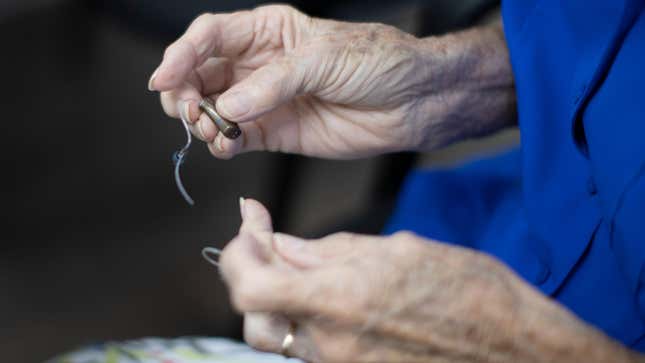 A person holding their hearing aids.
