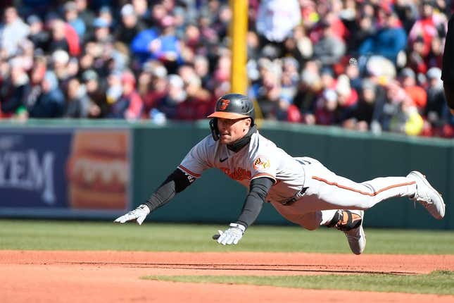Mar 30, 2023; Boston, Massachusetts, USA; Baltimore Orioles second baseman Adam Frazier (12) dives for second base against the Boston Red Sox  at Fenway Park.