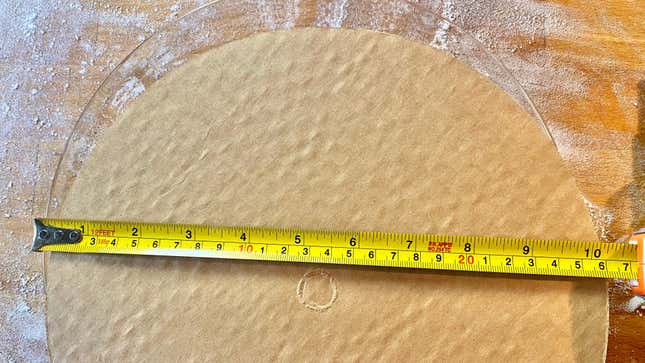 A cardboard circle with measuring tape over it.