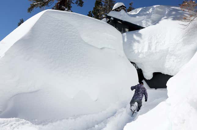 A man checks on his neighbor’s house in Mammoth Lakes, CA.